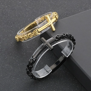 Detail of vintage Byzantine chain bracelets in gold and black with cross plate design
