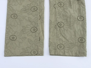 Detailed embroidery and hollow-out floral patterns on olive green trouser hem