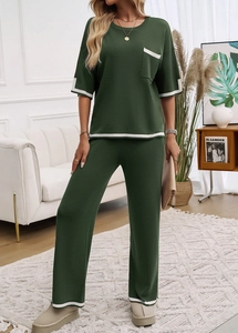 Détail de l'ensemble vert foncé montrant le liseré contrasté blanc au col et poche