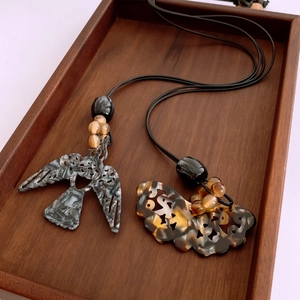 Collier ethnique avec pendentif en acétate en forme d'oiseau et perles d'ambre