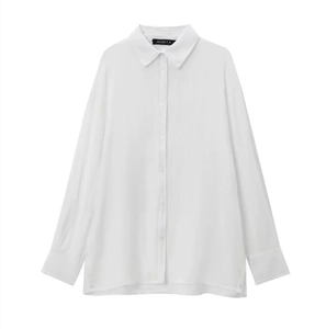Détail du tissu en lin blanc lisse et des poignets larges boutonnés de la chemise