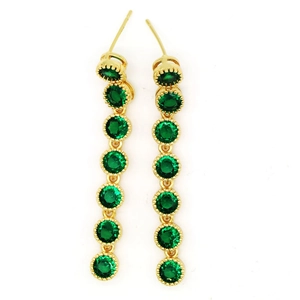 Macro detail of long gold drop earrings featuring seven green zircon stones in a row