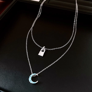 Détail du collier double rang argenté avec cadenas en zircon et pendentif lune