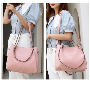 Detailed view of pink crocodile embossed tote bag with adjustable shoulder strap and handles