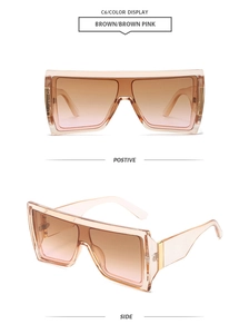 Detail of oversized square sunglasses with brown transparent frames and pink gradient lenses