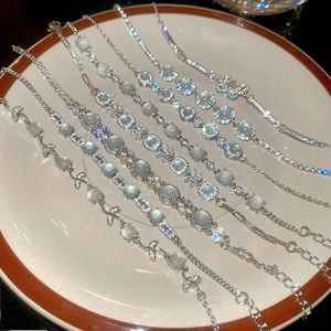 Détail de divers bracelets en argent avec zircon et pierre de lune sur porcelaine blanche