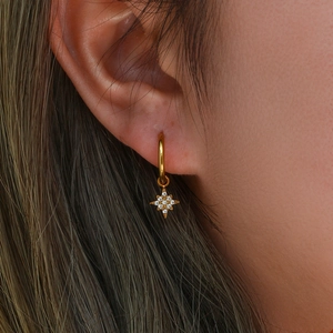 Close-up of 18K gold plated star hoop earrings with sparkling zircon on model