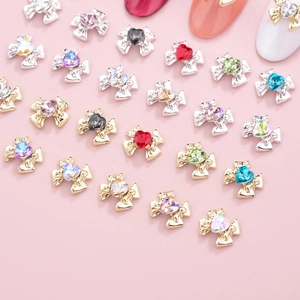 Detail of bow-knot nail art charms with heart-shaped rhinestones and alloy base