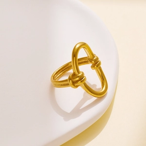 Macro shot of gold-plated knot ring detail with 18k finish and minimalist design