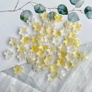 Macro shot of bicolor gradient resin flower beads with golden glitter for DIY jewelry making