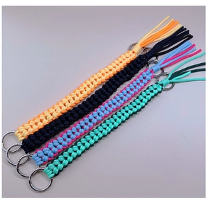 Close-up of four colorful handmade paracord keychains with metal rings in a neat row