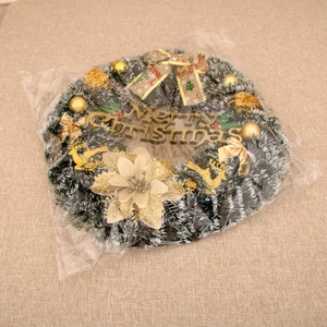 Detailed view of a Christmas wreath with gold bells, deer, and Merry Christmas sign