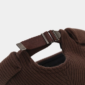 Détail du bonnet en maille côtelée marron avec boucle en métal et sangle de réglage