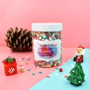 DIY Christmas slime kit with beads, sequins, and tree charms in a decorative plastic jar