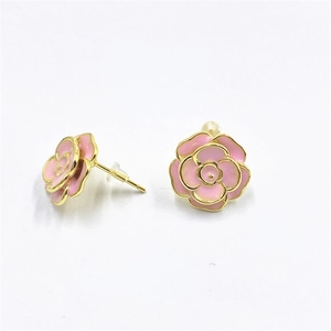 Detailed view of pink enamel flower earrings with gold plating and silicone backing