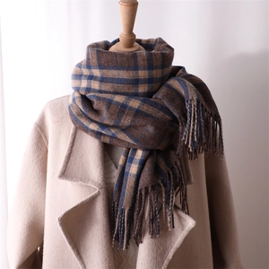 Close-up of a brown and blue plaid scarf with fringes styled on a mannequin neck