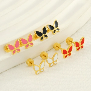 Close-up of four butterfly stud earrings with colorful enamel wings in gold-plated steel
