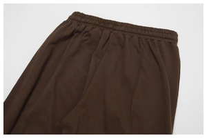 Detail of high-waist elastic waistband on brown cotton sweatpants with neat stitching