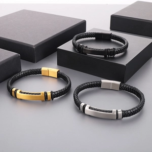 Three-color set of braided leather bracelets with metal nameplates on a black display box