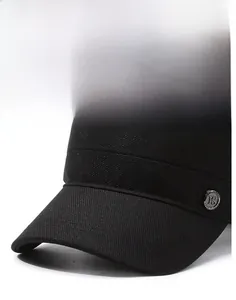 Detail of black cotton flat top army cap with metal FS badge and short stiff brim