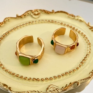 Detalle de anillos ajustables vintage bañados en oro con piedras de vidrio de colores