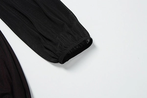 Detail of sheer black mesh sleeves with vertical texture and elastic ruffled cuffs