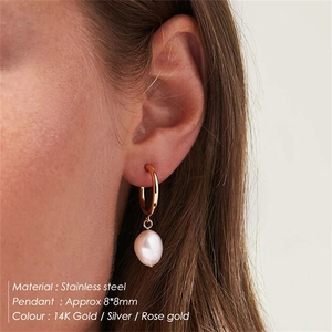 Detail shot of Baroque pearl drop earrings in stainless steel on a model's ear