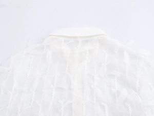 Detail of white semi-transparent fabric with elegant fringe and feather-like textures