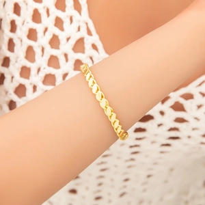 Elegant gold-tone leaf linked bracelet for women on model wrist with soft white background