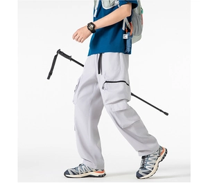 Dettaglio dei pantaloni cargo grigi con tasche tattiche e coulisse regolabile
