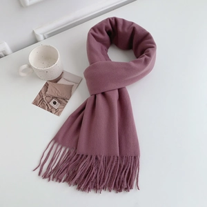 Detail of soft purple pink imitation cashmere scarf with fringes on a white desk