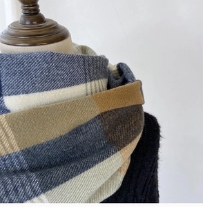 Close-up of checkered scarf texture in navy and brown with soft cashmere-like weave