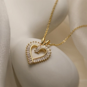 Macro shot of gold heart necklace pendant with micro-paved rectangular and round cubic zirconia