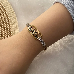 Gold chain bracelet featuring a butterfly motif and sparkling clear square zircons