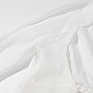 Macro di tessuto bianco leggero con trama verticale e materiale chiffon semitrasparente
