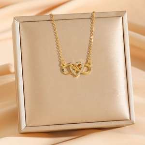 Elegant gold infinity heart pendant necklace with micro-pave crystals on satin fabric