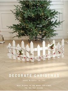Detail of white Christmas fence base decorated with red berries and branches for tree decor