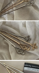 Detail of alloy hairpins with clover knot and heart scroll patterns in three metallic finishes