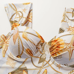 Detailed close-up of starfish and seashell prints on a white structured swimsuit cup