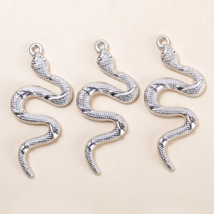 Three vintage silver snake charms for DIY jewelry making displayed on a neutral background