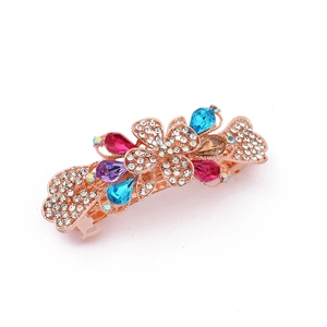 Detailed macro of rose gold bow hair clip with crystal flowers and colorful gemstones