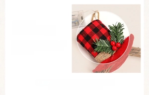 Detail of Christmas wreath featuring buffalo plaid mini hats, pine needles, and red berries