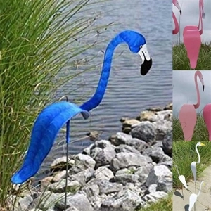 Detailed outdoor view of various colorful flamingo swirl bird wind spinners for garden decor