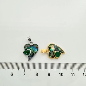 Detailed view of heart pendants with colorful shell inlay and scale for size reference