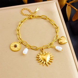 Detailed view of gold plated sunflower heart charms and white pearls on stainless bracelet