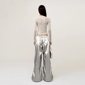 Detail view of silver metallic cargo pants with back flap pockets and slim grey knit top