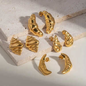 Golden conch and crescent stainless steel stud earrings set on minimalist stone steps