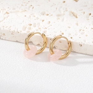 Detail of gold hoop earrings featuring a translucent pink natural stone bead pendant
