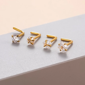 Macro view of gold stainless steel L-shaped nose studs with diverse zircon shapes