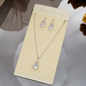 Macro detail of silver necklace and drop earrings set with sparkling zircon stones